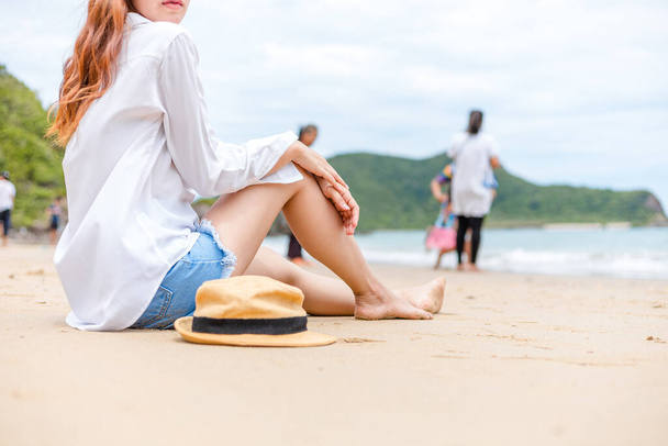 Una joven sentada sola en la playa de la isla. Concepto de viaje. - Foto, Imagen