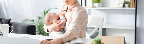 panoramic crop of mother breastfeeding baby boy at home - Photo, Image