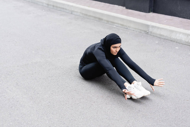 Arabian woman in hijab exercising on asphalt  - Valokuva, kuva