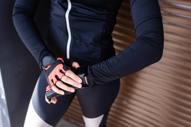 cropped view of woman standing and touching sport gloves  - Foto, Imagem