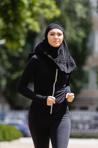 joven árabe chica en hijab y ropa deportiva trotando fuera
 - Foto, Imagen