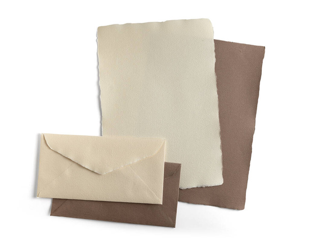 Hojas de papel y sobres hechos a mano de color beige natural, aislados del fondo. contiene ruta de recorte
 - Foto, imagen