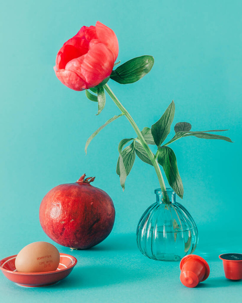 Red peony with pomegranate and egg on the light blue background still life photo - Zdjęcie, obraz