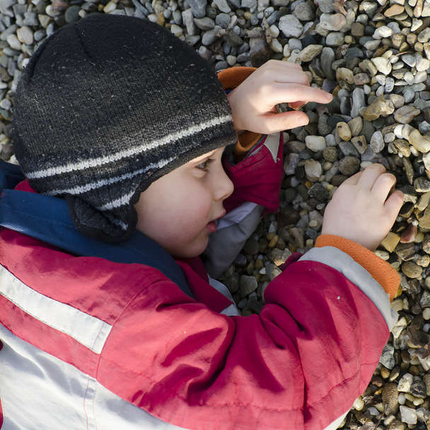 Child playing with pebbles - Фото, изображение