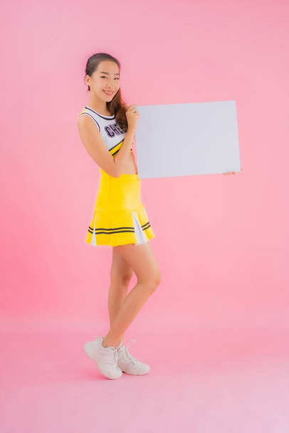 Portrait beautiful young asian woman show white empty billboard for text on pink isolated background - Photo, Image