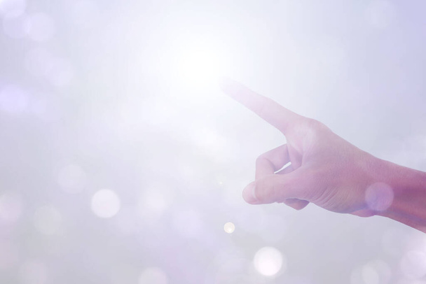 Hand zeigt auf weißen Linsenschlag Sonnenlichteffekt isoliert auf Bokeh-Hintergrund - Foto, Bild