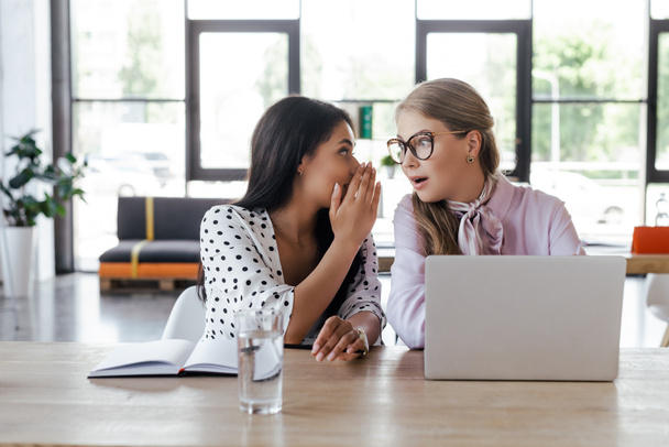 businesswomen gossiping near laptop in modern office - Photo, Image