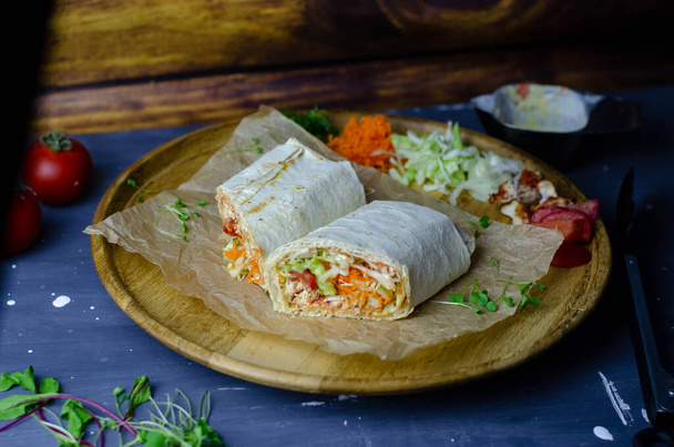 Shawarma casero / burrito / rollo de pollo con verduras y salsa. Ingredientes vista superior
 - Foto, imagen