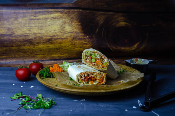 Shawarma casero / burrito / rollo de pollo con verduras y salsa. Ingredientes vista superior
 - Foto, Imagen