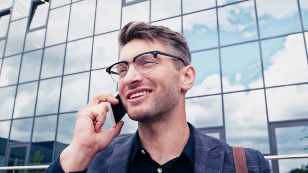 Ευτυχισμένος άνθρωπος με γυαλιά μιλώντας στο smartphone έξω - Πλάνα, βίντεο