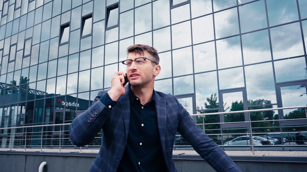 красивий чоловік в окулярах говорить на смартфоні зовні
 - Кадри, відео