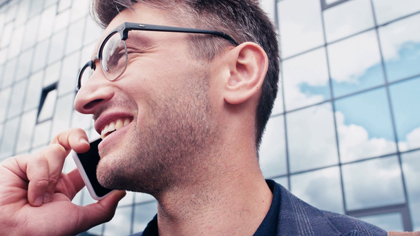 primer plano de hombre feliz en gafas hablando en el teléfono inteligente fuera
 - Metraje, vídeo