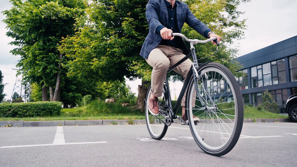 vista ritagliata dell'uomo in sella alla bicicletta all'esterno  - Filmati, video
