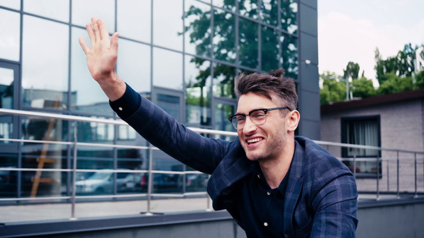 happy man in glasses waving hand near building  - Footage, Video