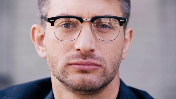 close up of handsome man in glasses looking at camera - Imágenes, Vídeo