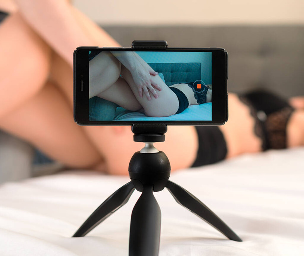 Couple recording their adult video on mobile phone. - Foto, imagen