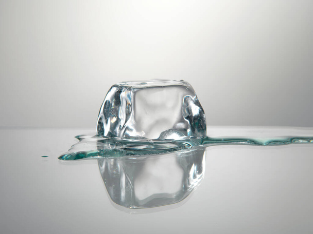 Ice cube on neutral mirror background - Foto, Imagen
