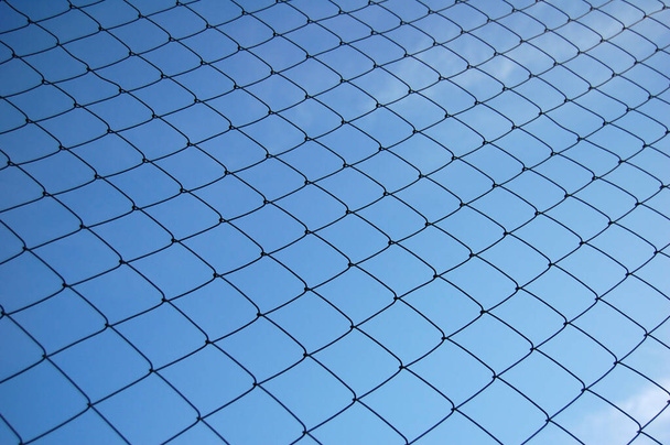 Kék égbolt hátterű fémháló - Fotó, kép