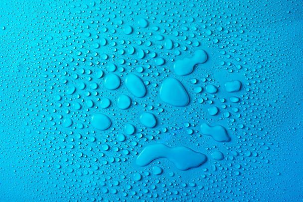 Σταγόνες νερού σε φόντο μπλε γυάλινης υφής - Φωτογραφία, εικόνα