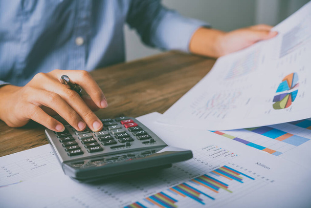 close up L'imprenditore è seduto su una calcolatrice con un grafico nell'ufficio di contabilità finanziaria - Foto, immagini