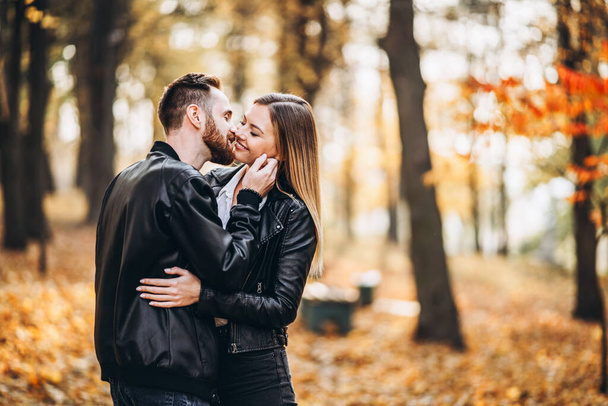 Portrait of a young loving couple. Man and woman hugging and smiling in the background of autumn park. - Valokuva, kuva