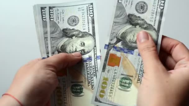A személy 100 dollár bankjegyeket számol a kezében. Fehér háttér. Egy rakás pénz. Gazdag ember. Több ezer dollár.. - Felvétel, videó