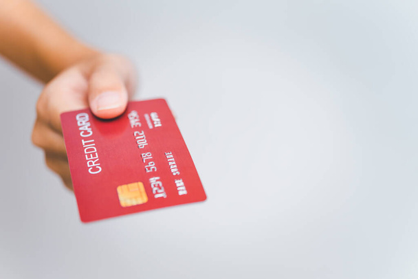 mão da mulher segurando um cartão de crédito em um fundo branco. Pagamento online para compras online
 - Foto, Imagem