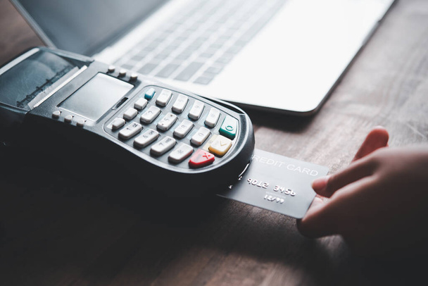 Betalen met een creditcard, producten kopen en verkopen met een credit card swipe machine voor gemak en snelheid, inclusief online winkelen - Foto, afbeelding