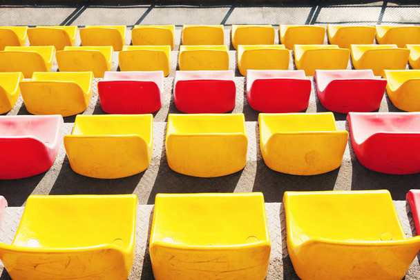 Stade vide. Rangées de sièges jaunes et rouges dans le stade. Concept de stade vide sans spectateurs, temps de quarantaine - Photo, image