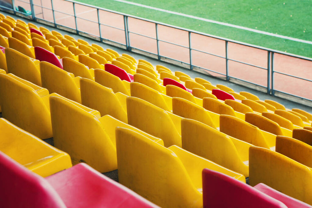 Estadio vacío. Filas de asientos amarillos y rojos en el estadio. Concepto de estadio vacío sin espectadores, tiempo de cuarentena
 - Foto, Imagen