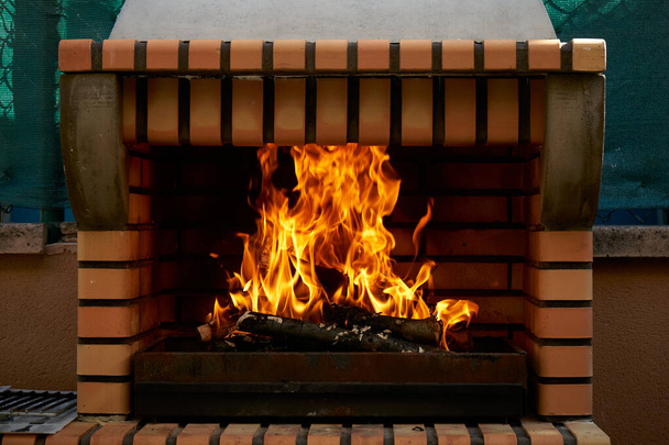 Огонь, зажженный в саду барбекю
 - Фото, изображение
