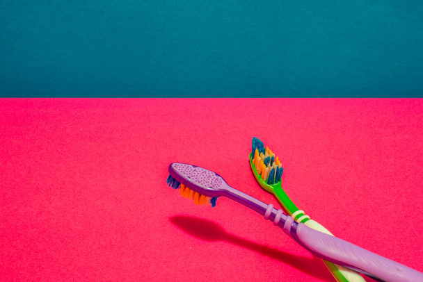 Two tooth brushes on pink and blue background - Photo, Image