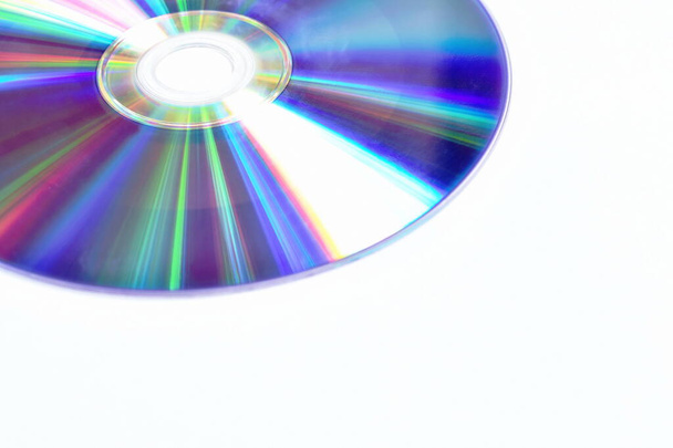 CD of DVD met kleurrijke lichtreflectie op het oppervlak in witte achtergrond - Foto, afbeelding