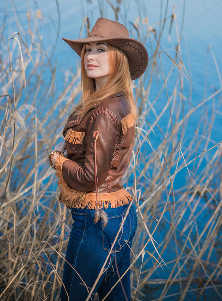Девушка в кожаном пиджаке в американском стиле кантри и шапке-ушанке на природе
 - Фото, изображение
