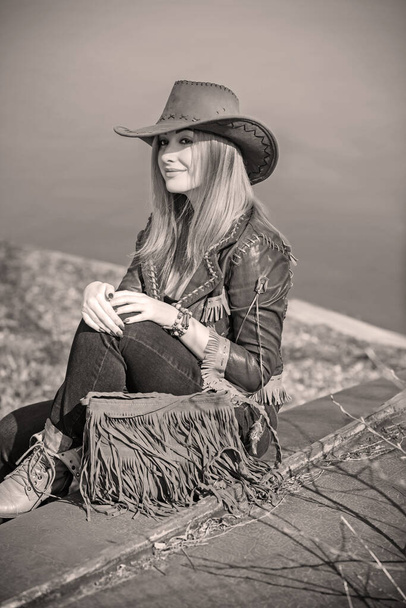 Girl in American country style leather boho jacket and cowboy hat at nature - Fotoğraf, Görsel