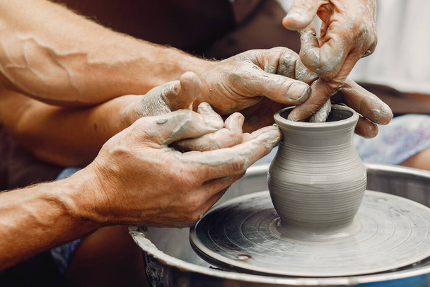 Grandmother with a grandchildren make pitchers in pottery - Fotó, kép