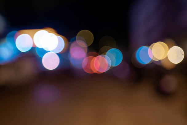 A blurred shot of many colorful lights glowing in the street at night - Fotografie, Obrázek