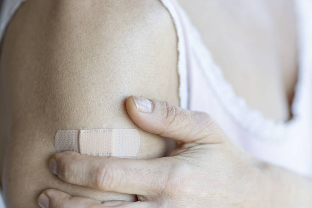 A bandage on a woman's arm next to her hand - Foto, Imagem