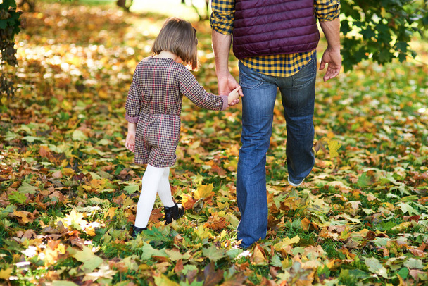 Sonbahar ormanlarında yürüyen çocuk ve babanın dikiz aynasından.  - Fotoğraf, Görsel