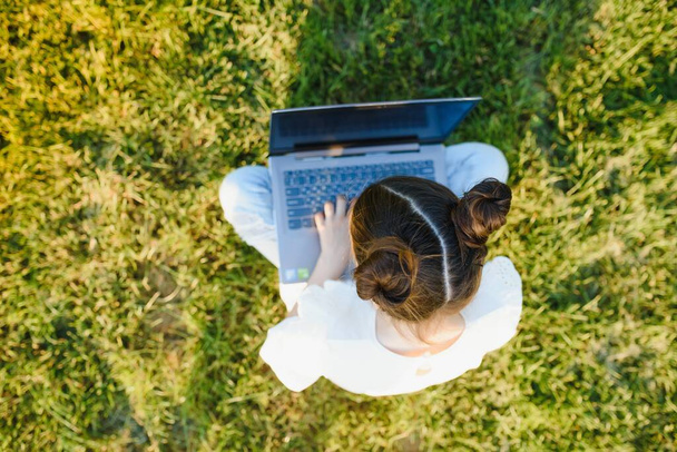 little girl play computer on green grass - Foto, immagini
