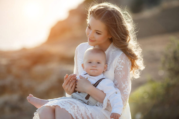 Beautiful pretty woman with baby boy on sunset outdoors. mother with son - Photo, image