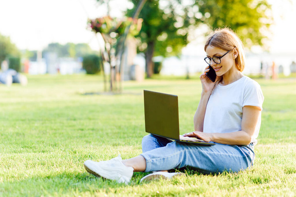 Attractive girl with a laptop in the park - Foto, Bild
