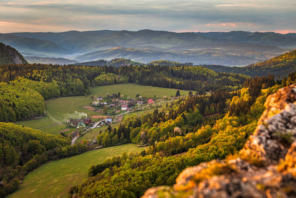 Paysage montagneux au coucher du soleil au printemps. Vue depuis le sommet de la colline rocheuse de Bosmany au-dessus du village de Kostolec dans le nord-ouest de la Slovaquie, en Europe
. - Photo, image