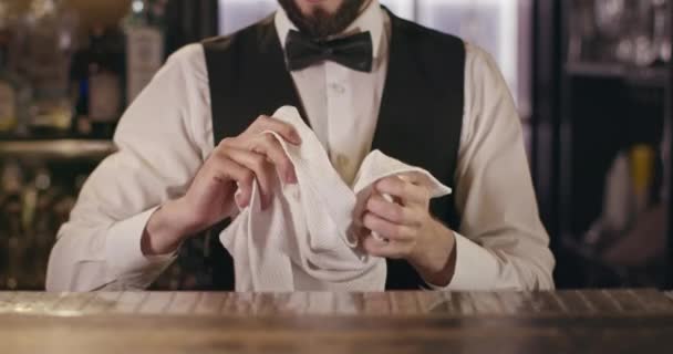 Barman wyciera szklankę ręcznikiem. 4k - Materiał filmowy, wideo