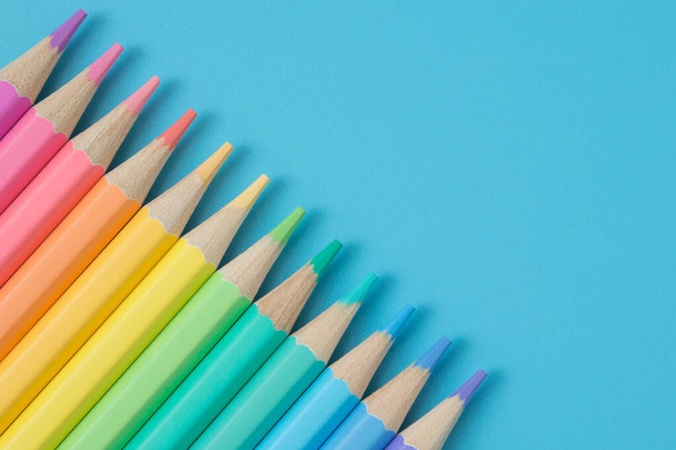 Modèle coloré de crayons de couleur pastel sur fond bleu et espace de copie - Photo, image