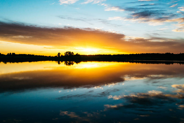 Summer sunset on the lake with a mirror reflection of the sky - Foto, Imagem