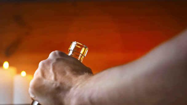abgeschnittene Ansicht eines Mannes, der eine Flasche Weißwein mit Korkenzieher öffnet - Filmmaterial, Video
