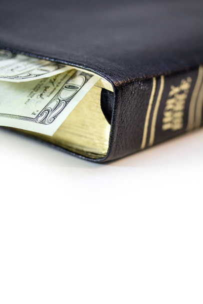 Svatá křesťanská bible s dvacetidolarovou bankovkou izolovanou na bílém pozadí. - Fotografie, Obrázek