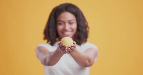 Manzana verde fresca en manos de una amigable chica afroamericana
 - Metraje, vídeo