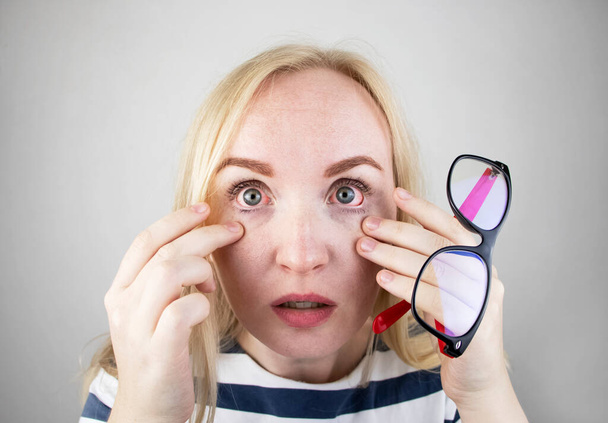 Kobieta pociera jego zmęczone oczy dłońmi o białe tło. Koncepcja zmęczenia oczu przez komputer i zmęczenia przez pracę. Ból oczu i czoła, migrena, choroby oczu - Zdjęcie, obraz